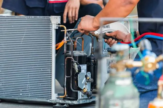 Technician repairing components inside an HVAC system