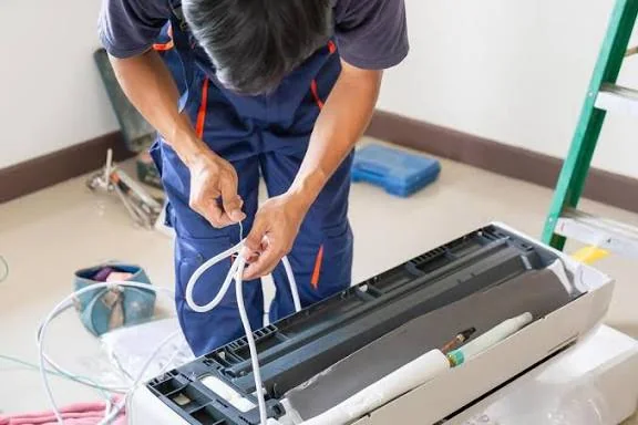 Technician connecting control wiring during mini-split installation